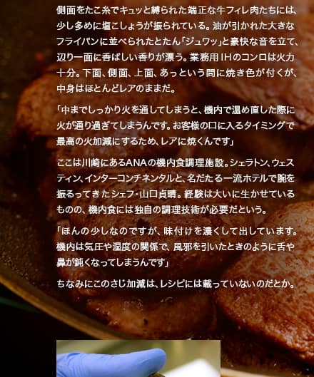 側面をたこ糸でキュッと縛られた端正な牛フィレ肉たちには、少し多めに塩こしょうが振られている。油が引かれた大きなフライパンに並べられたとたん「ジュワッ」と豪快な音を立て、辺り一面に香ばしい香りが漂う。業務用IHのコンロは火力十分。下面、側面、上面、あっという間に焼き色が付くが、中身はほとんどレアのままだ。「中までしっかり火を通してしまうと、機内で温め直した際に火が通り過ぎてしまうんです。お客様の口に入るタイミングで最高の火加減にするため、レアに焼くんです」ここは川崎にあるANAの機内食調理施設。シェラトン、ウェスティン、インターコンチネンタルと、名だたる一流ホテルで腕を振るってきたシェフ・山口貞晴。経験は大いに生かせているものの、機内食には独自の調理技術が必要だという。「ほんの少しなのですが、味付けを濃くして出しています。機内は気圧や湿度の関係で、風邪を引いたときのように舌や鼻が鈍くなってしまうんです」ちなみにこのさじ加減は、レシピには載っていないのだとか。