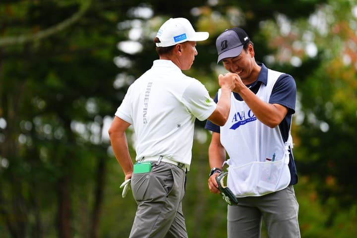 ホールアウト後にキャディとグータッチを交わす選手