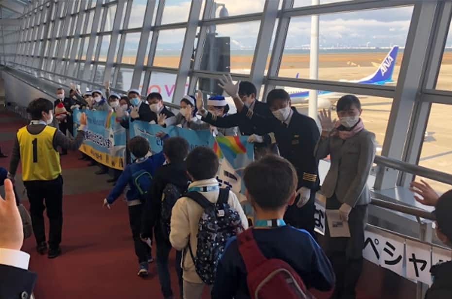 機内へ向かう子供たちをお見送りする画像