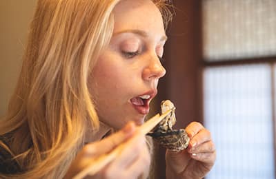 くにさきオイスターを食べようとしている女性