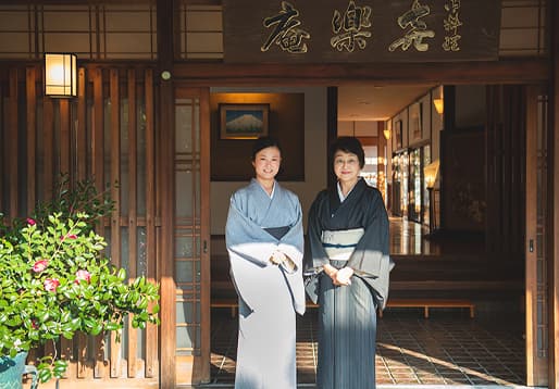 喜楽庵の前に立つ若女将・山本祐子さんと女将