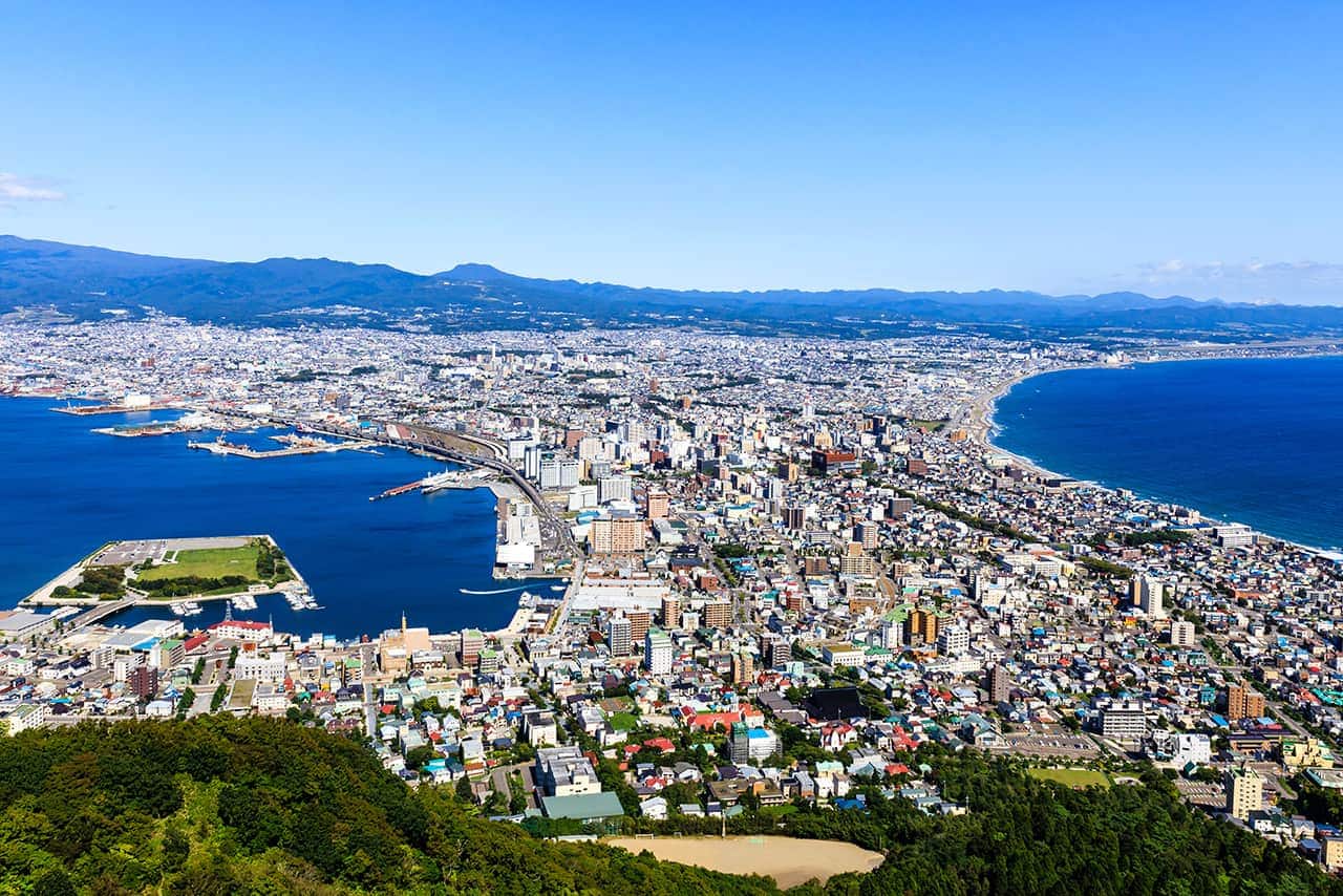 精選圖片：俯瞰以山海為背景的沿海城市全景。