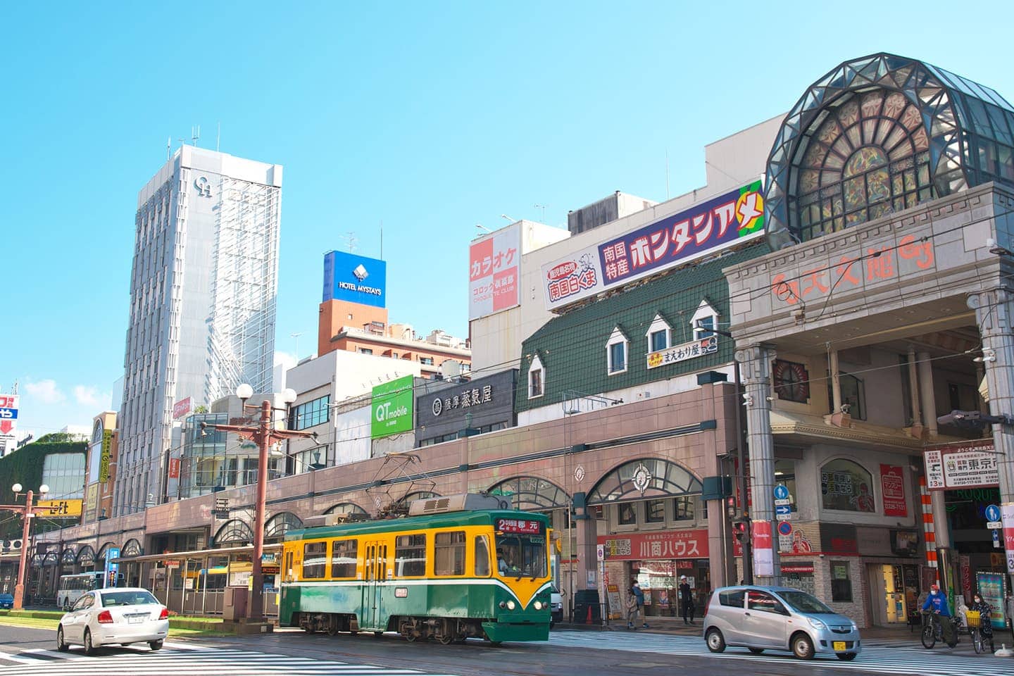 精選圖片：有電車和拱廊的城市街景。